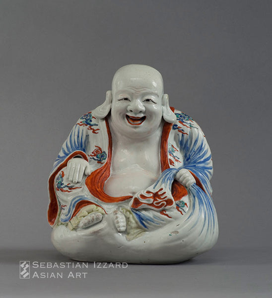 SEATED FIGURE OF A SMILING HOTEI Hizen ware, Kakiemon type porcelain with overglaze colored enamel decoration 9-7/8 in. (25 cm) high  Edo period, late 17th century