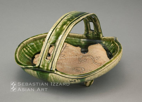 BASKET WITH STRAP HANDLE ON THREE LOOP FEET (TEBACHI)  Mino ware, Narumi Oribe type: stoneware with crackled glaze, iron brown painted decoration, and rich green overglaze Momoyama period, late 16th/early 17th century  14 x 35.5 x 33.5 cm