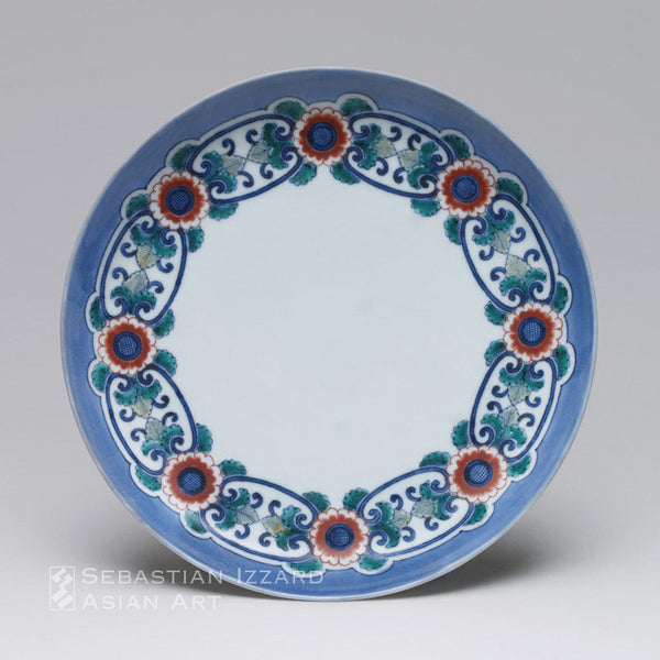 PORCELAIN DISH WITH CHRYSANTHEMUM CHAIN DESIGN Hizen ware, Nabeshima type:  porcelain with underglaze blue,  iron red and colored enamels  Early Edo period, ca. 1650–60  H: 4.6 cm; D: 19.7 cm