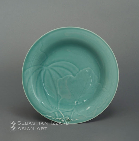 FOOTED DISH (SHAKUZARA) WITH MELON AND LEAFING VINE DESIGN Hizen ware, Nabeshima type: porcelain with carved decoration under celadon glaze  Edo period (1615–1868), Genroku era, circa 1700 Height 2-5/8 in. (6.7 cm); diameter 11¼ in. (28.7 cm)