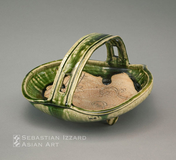BASKET WITH STRAP HANDLE ON THREE LOOP FEET (TEBACHI) Mino ware, Narumi Oribe type: stoneware with crackled glaze, iron brown painted decoration, and rich green overglaze Momoyama period, late 16th/early 17th century 14 x 35.5 x 33.5 cm